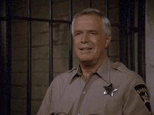 a man in a sheriff 's uniform has a badge that says sheriff on it