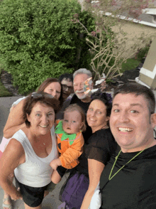 a group of people posing for a picture with a baby in the middle