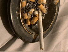 an ashtray filled with cigarettes and a rolled cigarette