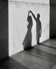 a shadow of a man and a woman holding hands