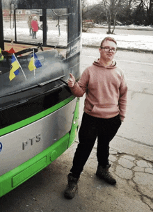 a man giving a thumbs up in front of a bus that says pts