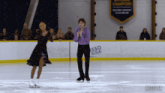 a man and a woman are ice skating in front of a banner that says sso rink
