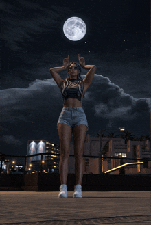 a woman stands in front of a full moon with her hands in the air