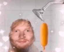 a man is taking a shower with a banana hanging from a shower head .