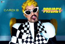 a man with yellow hair and sunglasses is sitting in a chair with the word privacy behind him