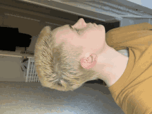 a young man with short blonde hair is laying down