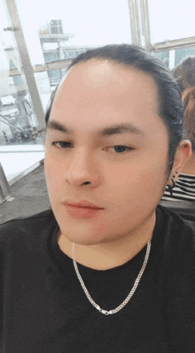 a man wearing a black shirt and a silver chain