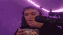 a blurry picture of a person holding a cup in front of a purple wall