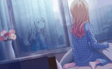 a girl is sitting in front of a window looking out