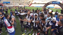 a group of soccer players on a field with one wearing a jersey that says ' alianza ' on it