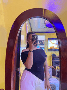 a woman taking a selfie in a mirror with her phone