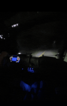 a blurred image of a car dashboard at night with a speedometer