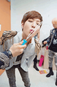 a woman blowing soap bubbles with a blue bubble wand