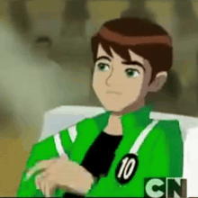 ben 10 from ben 10 is wearing a green jacket and sitting on a chair .
