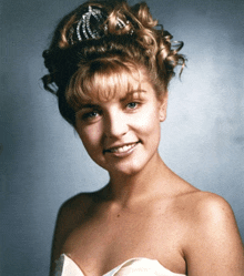 a woman wearing a tiara on her head smiles for the camera