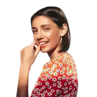 a woman wearing braces is smiling and touching her face with her hand .
