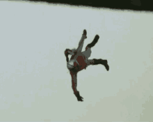 a person is flying through the air and doing a handstand while wearing a helmet .