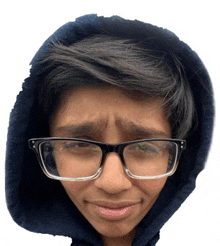 a young boy wearing glasses and a hood is making a funny face .