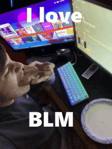 a man is sitting in front of a computer with the words " i love blm " on the screen