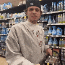a man wearing a hat and a sweatshirt is shopping in a store .