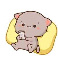 a cartoon cat is sitting on a pillow and holding a cell phone .