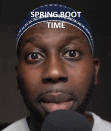 a man wearing a blue hat with the words spring boot time written on it