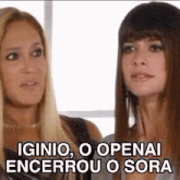 two women are standing next to each other and talking to each other in a room .