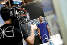 a man in a scrub is being filmed by a camera