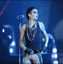 a man singing into a microphone while wearing leopard print pants and gloves