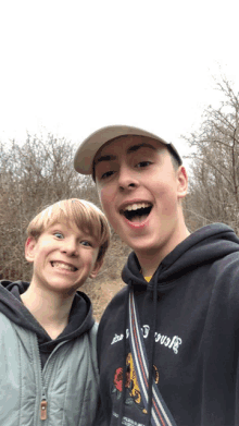 two boys are posing for a picture and one has a hoodie that says jesus