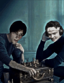 two men playing chess with a louis vuitton briefcase in the foreground