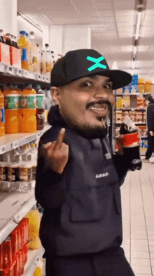 a man wearing a hat with an x on it is giving the middle finger in a grocery store .