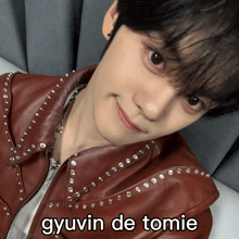a close up of a person 's face with the words gyuvin de tomie above it