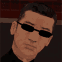 a man wearing sunglasses and a black shirt is looking at the camera