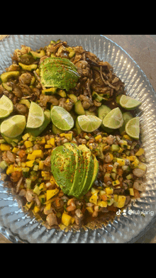 a plate of food with avocado limes and shrimp on it