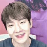 a close up of a person 's face with a purple background and a smile on their face .