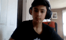 a boy wearing headphones looks at the camera