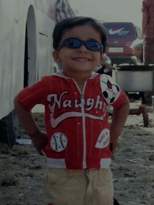 a little boy wearing sunglasses and a naughty shirt