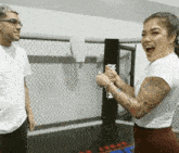 a man and a woman are standing next to each other in a boxing ring with a sign that says iron