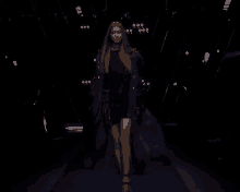 a woman in a black dress walks down a runway