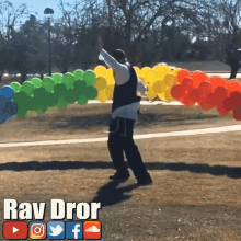 a man is standing in front of a bunch of balloons with the name ray dror on the bottom right