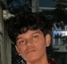 a young man with curly hair is looking at the camera and making a funny face .