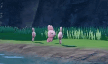 a group of pink stuffed animals are standing in the grass near a body of water .