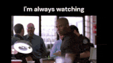 a man is standing in front of a group of police officers with the words i 'm always watching above him