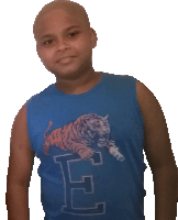 a boy wearing a blue tank top with a tiger on it