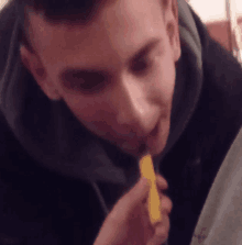 a man is eating a yellow item with a spoon