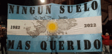 a man holds up a large banner that says ningun suelo mas querido