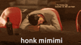a picture of a man laying on a bed with the words honk mimimi below him