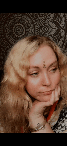 a woman with a bindi on her forehead is looking down