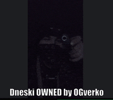 a man holding a gun with the words dneski owned by ogverko below him